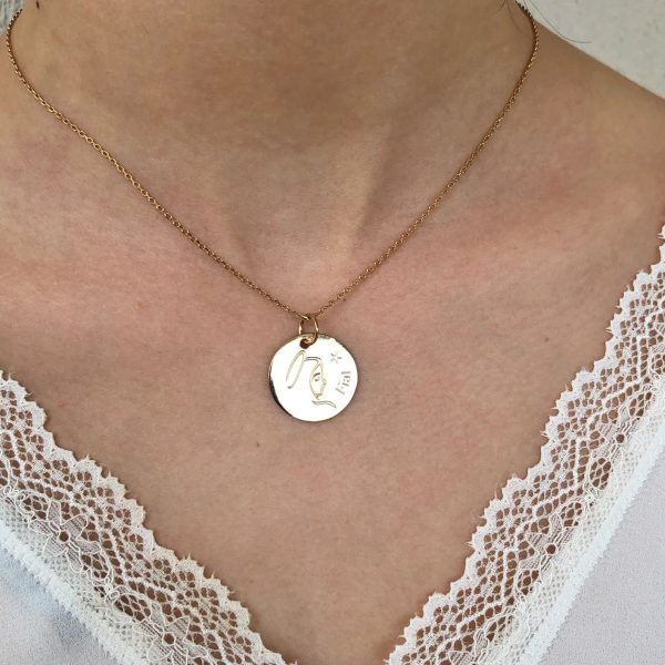 Collier Fiat doré autour du cou d’une femme, bijou religieux discret et élégant
