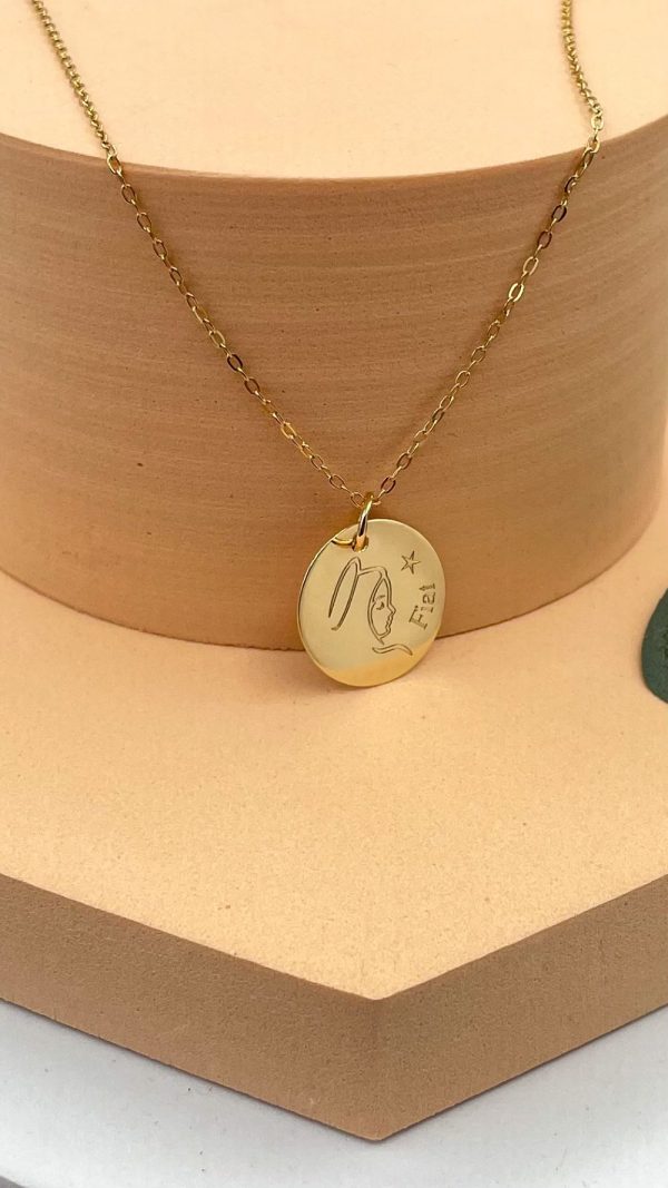 Gros plan sur la médaille en plaqué or Vierge Marie Fiat posée sur fond nude, bijou spirituel