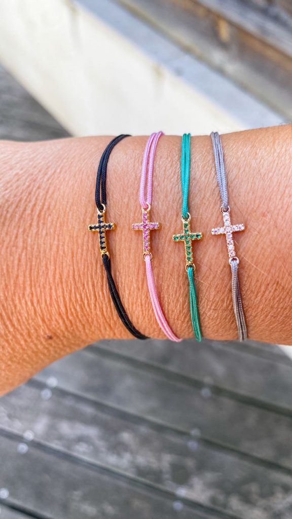 Zoom sur bracelet religieux femme – croix en strass sur cordon rose, noir, vert, gris
