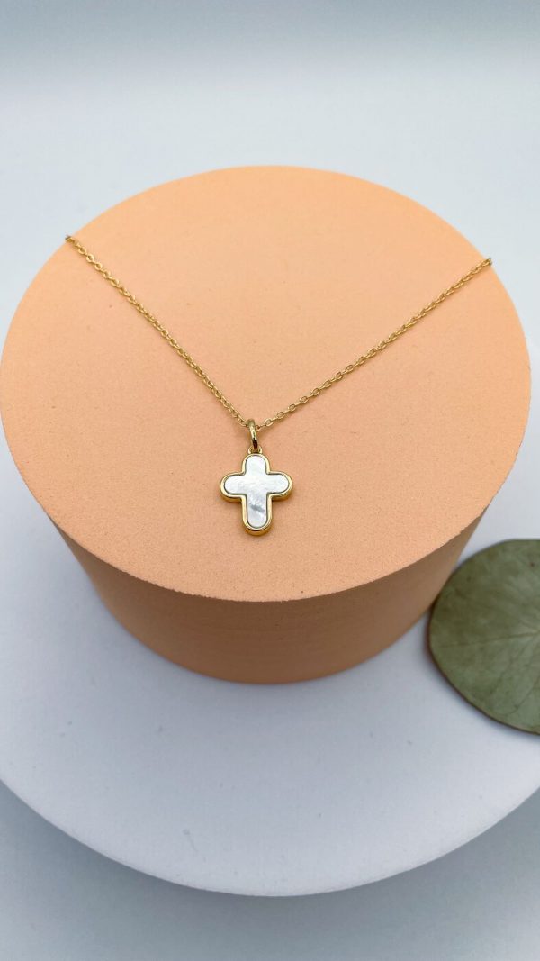 Pendentif croix en nacre sertie posé sur support beige - collier religieux en plaqué or Christ Roi