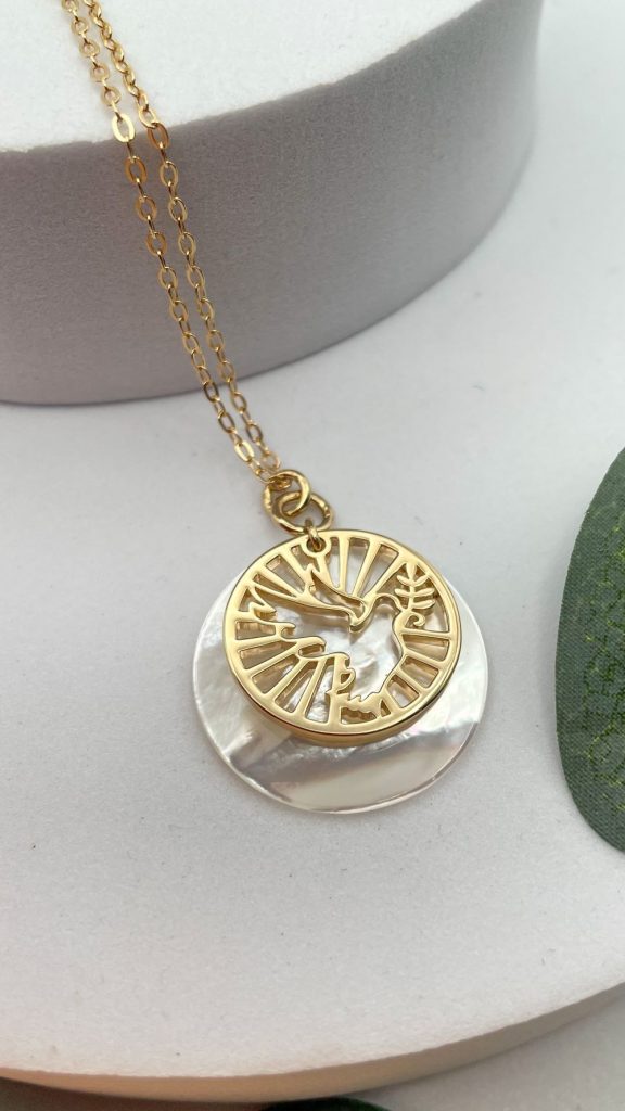 Collier colombe ajourée dorée sur nacre blanche symbole de paix et lumière divine
