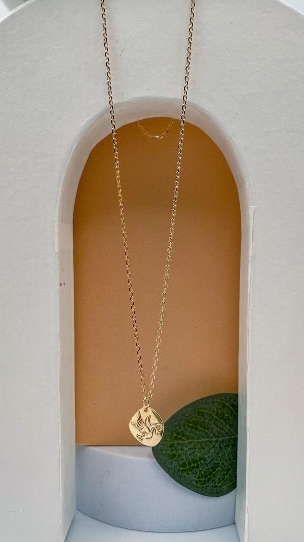 Collier colombe suspendu dans une arche décorative avec feuille verte en arrière-plan