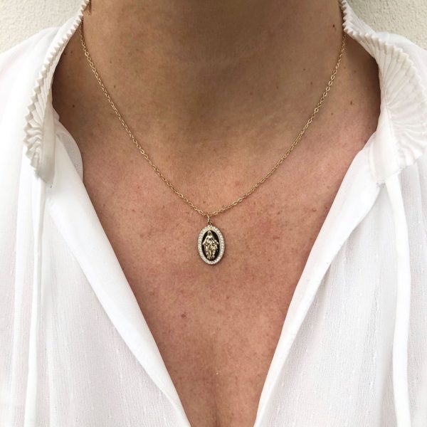 Collier catholique avec médaille de la Vierge porté en ras de cou sur chemisier blanc