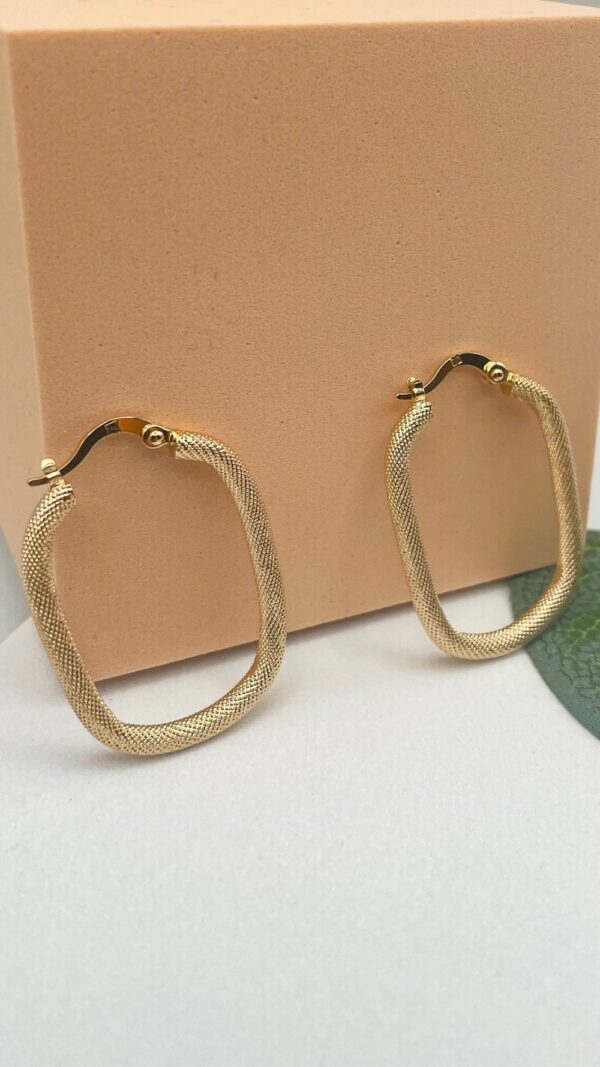 Boucles d’oreilles créoles rectangulaires texturées en plaqué or posées sur un bois flotté – modèle Sumatra
