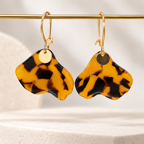 Boucles d’oreilles pendantes effet écaille de tortue aux nuances ambrées et marron, avec crochets dorés et petites pastilles rondes.