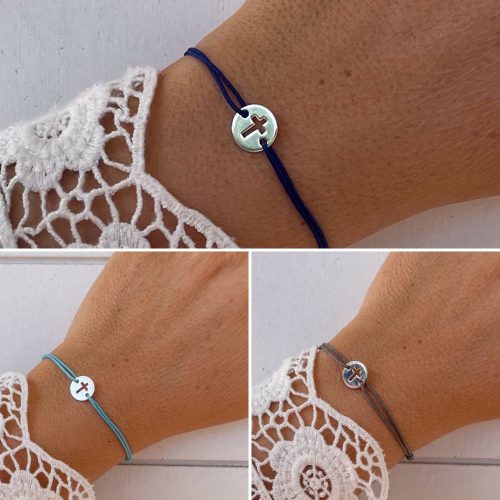 Bracelet croix ajustable argent 10 mm sur lien gris, bijou chrétien moderne porté au poignet femme.
